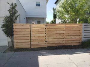 A newly installed modern horizontal slat wood fence with a gate by Allied Fence Co in Tulsa, OK.