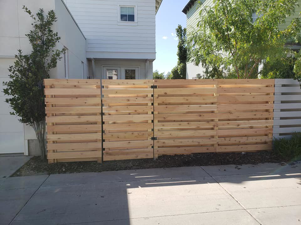 A newly installed modern horizontal slat wood fence with a gate by Allied Fence Co in Tulsa, OK.