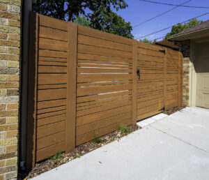 A modern horizontal slat wooden fence with a matching gate installed by Chisel + Vine in Milwaukee, WI.