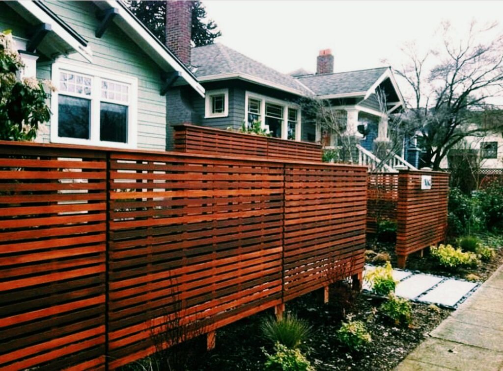 A modern horizontal slat wooden fence providing privacy for a residential property by Valkyrie construction, LLC in Granville, OH.