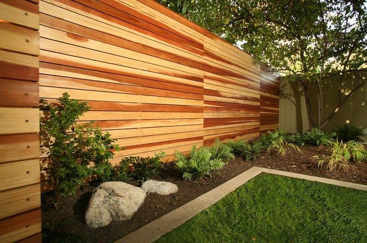 A modern horizontal slat wood fence providing privacy in a backyard, installed by Colorado Fence and Gate Systems in Colorado Springs, CO.