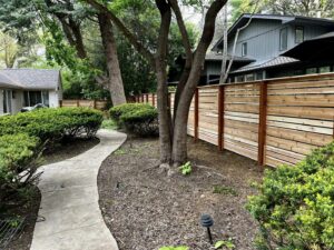 A modern horizontal wood fence installed around a residential property by Custom Vinyl Fabrication in Omaha, NE.