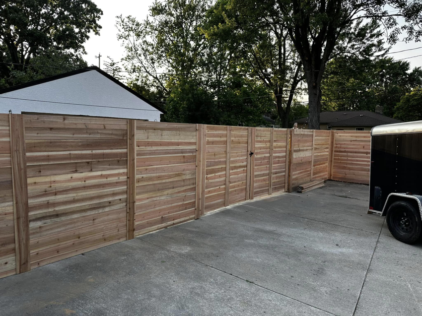 A modern horizontal slat wood fence with a matching gate installed for privacy by CDM Home Solutions in Columbus, OH.