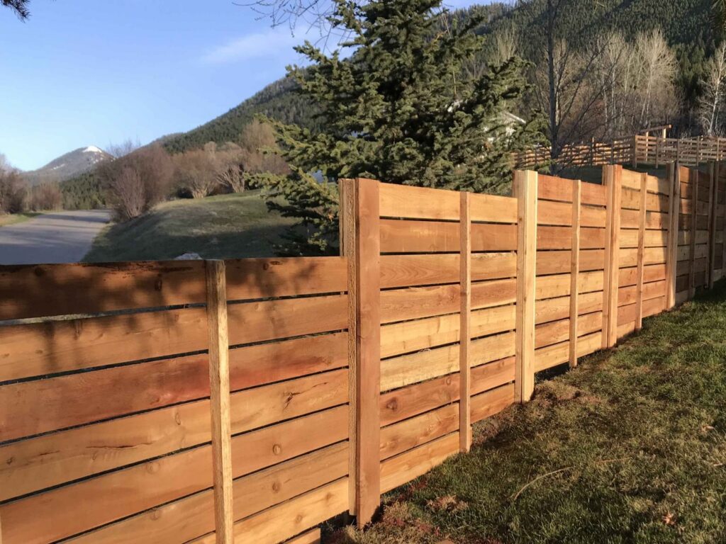 A modern horizontal slat wood fence installed along a roadside by Prestige Fencing LLC in Medford, OR.