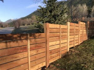 A modern horizontal slat wood fence installed along a roadside by Prestige Fencing LLC in Medford, OR.