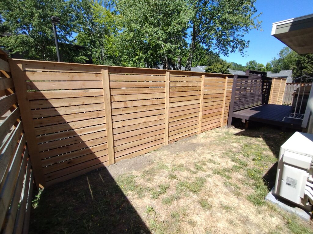 A modern horizontal slat wood fence installed by Stewart & Son Gate & Fence Co. in Hillsboro, OR