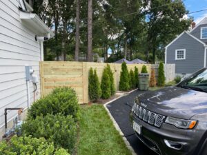 A modern horizontal wood privacy fence installed alongside a driveway by Superior Fence & Rail Richmond, VA.