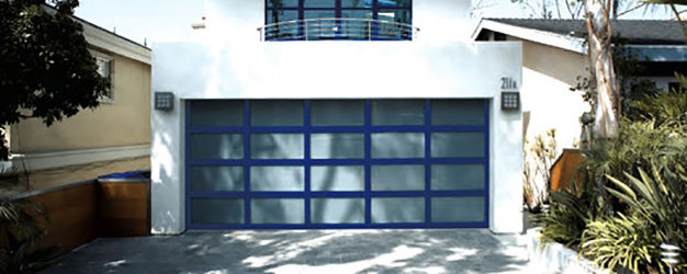 A modern house showcasing a blue garage door with frosted glass panels by Overhead Door Company of Knoxville in Knoxville, TN