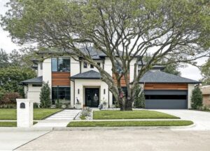 A modern house with a sleek dark gray garage door and wooden accents, installed by Monroe Overhead Doors in Monroe, LA.