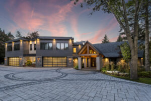 A large modern house featuring multiple contemporary glass garage doors, installed by Madison Overhead Garage Door Services in Madison, WI.