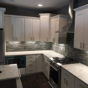 A modern kitchen featuring new electrical outlets and under-cabinet lighting installed by Arc-n-Spark Electric in Cheyenne, WY.
