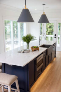 Modern kitchen island with stylish pendant lights and under-cabinet lighting installed by Ampler Electrical Services in Wilmington, NC.