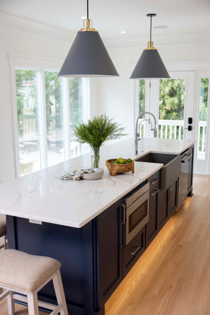 Modern kitchen island with stylish pendant lights and under-cabinet lighting installed by Ampler Electrical Services in Wilmington, NC.