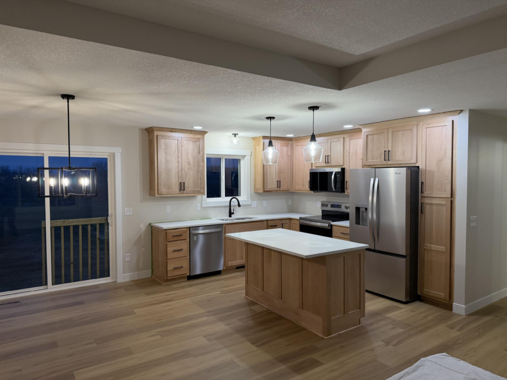 A modern kitchen showcasing new lighting fixtures and appliance wiring completed by Power Plus Electric LLC in Rochester, MN.