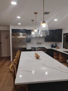 A modern kitchen featuring recessed lighting and stylish pendant lights over the island, installed by Envision Electrical Solutions in Fort Lauderdale, FL.