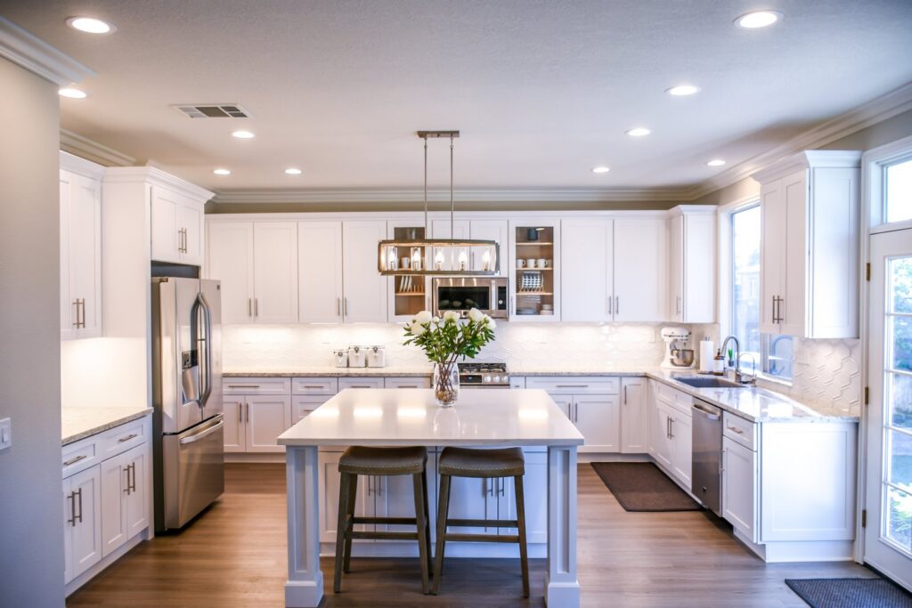 A modern kitchen featuring recessed lighting, pendant lights, and under-cabinet lighting installed by Homestead Electric in Orem, UT.