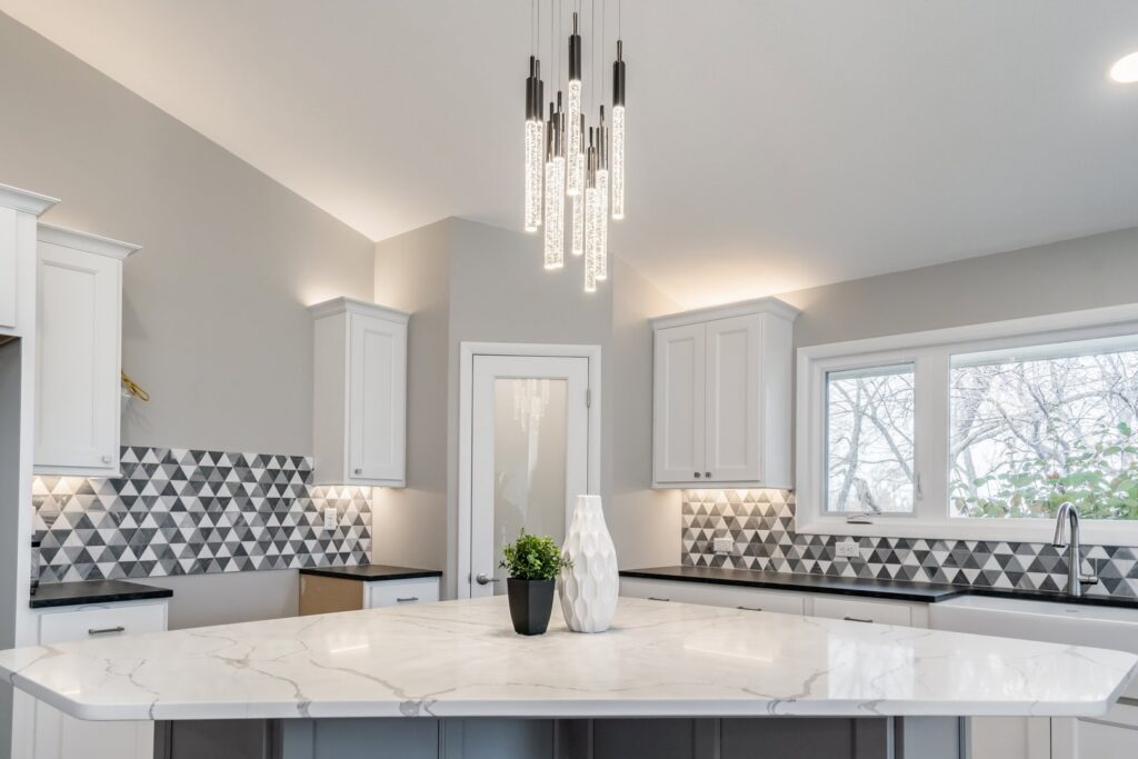Modern kitchen featuring a unique chandelier and under-cabinet lighting installed by Innovative Electric in Wichita, KS.