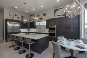 Modern kitchen with stylish pendant lights and a chandelier installed by Lundell Electrical Services in Mesa, AZ.