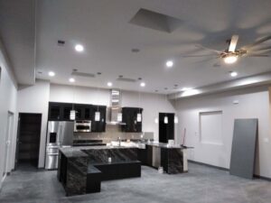 A modern kitchen featuring new recessed lighting, pendant lights, and a ceiling fan installed by The Specialist Electrical Contractor in Albuquerque, NM.