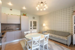 Modern kitchen and living room with chandelier and recessed lighting installed by Down The Road Electric Inc in Iowa City, IA