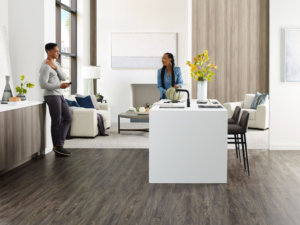 A modern living room featuring both dark wood-look flooring and a light gray carpeted area by Jerry's Carpet Sales and Service in York, PA.