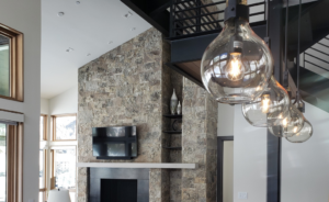 Modern living room with pendant lights, recessed lighting, and mounted TV installed by TBS Electric in West Jordan, UT.