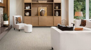 A modern living room with stylish furniture and a newly installed light-colored textured carpet by Floors By Tomorrow in Aurora, CO