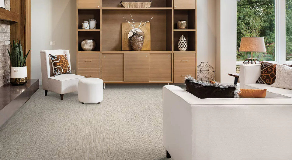 A modern living room with stylish furniture and a newly installed light-colored textured carpet by Floors By Tomorrow in Aurora, CO