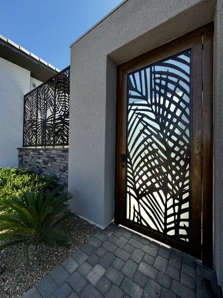 A modern metal gate and fence panel featuring a unique palm leaf design by Custom Customs Inc. in Henderson, NV.