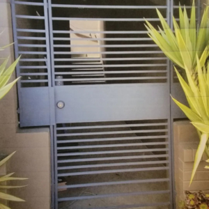 A modern metal security gate with horizontal bars installed by Fierro Iron Works Inc. in San Francisco, CA.