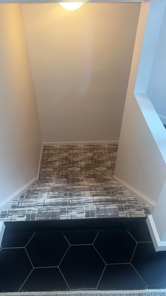 A modern patterned stair runner installation by Christie Carpets & Blinds, a carpet contractor in Rochester, NY