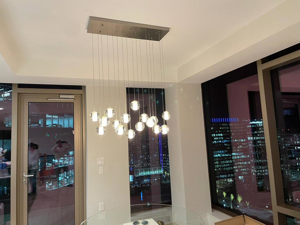 A modern multi-pendant chandelier installed in a room by Ramos Electrical services inc in Brownsville, TX
