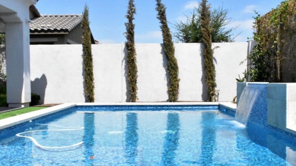 A modern, sparkling clean pool with a beautiful waterfall feature, showcasing quality pool care from Prime Pool Care in Scottsdale, AZ