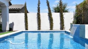 A modern, sparkling clean pool with a beautiful waterfall feature, showcasing quality pool care from Prime Pool Care in Scottsdale, AZ