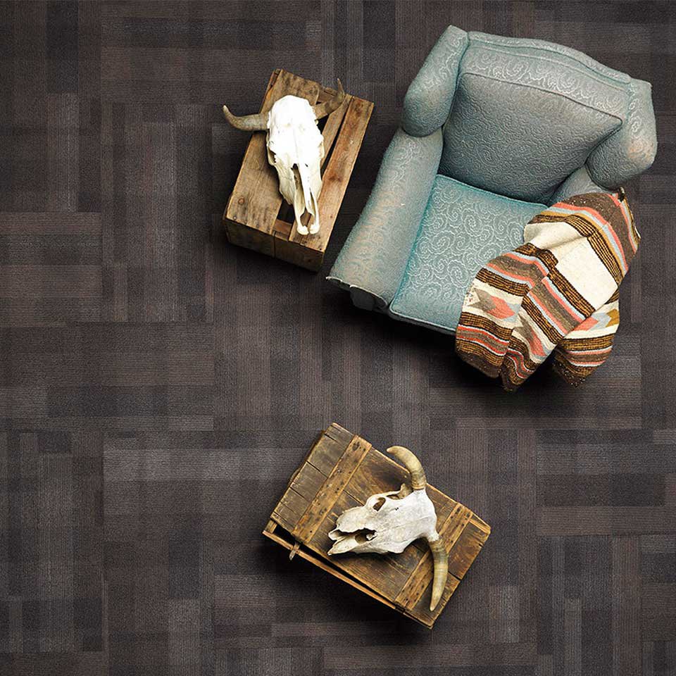 A modern room featuring dark grey square patterned carpet, professionally installed by Eastpointe Interiors in Caledonia, MI.