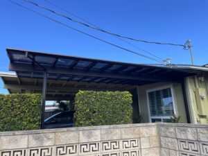 A newly installed modern vertical slat fence along a grassy area by KunkelWorks Hawaii in Mililani, HI.