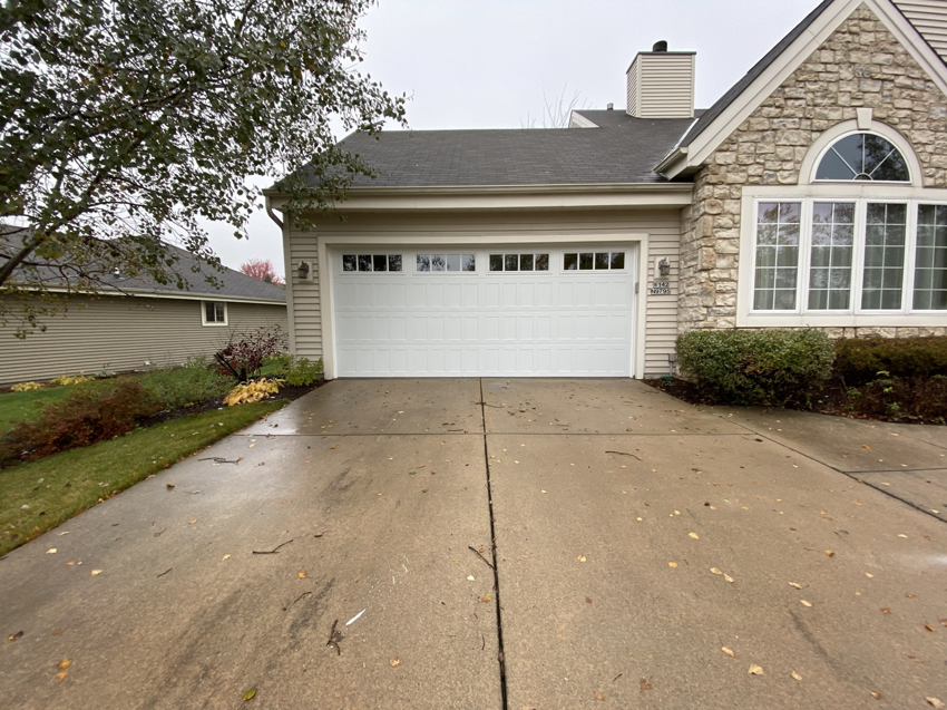 A modern white garage door with top panel windows installed by Geiszler Garage Door in Milwaukee, WI.