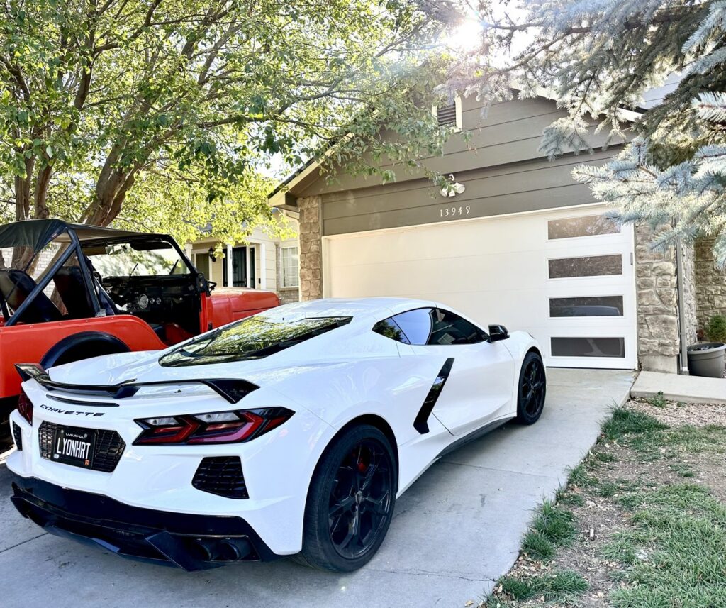 A modern white garage door with horizontal windows installed on a home by Lion Heart Garage Doors in Thornton, CO.