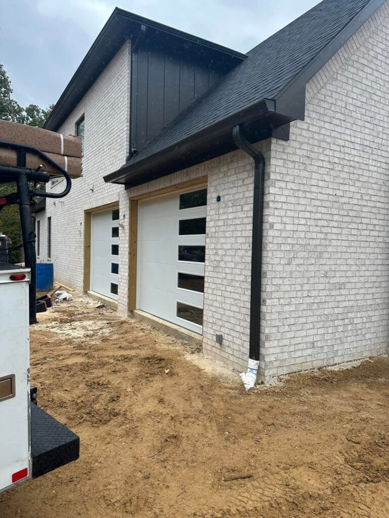 Modern white garage doors with horizontal windows installed on a brick home by Platinum Garage Door Services in Helena, AL