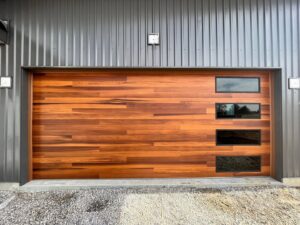 A modern wood grain garage door with horizontal windows installed by 314 Overhead Doors in O'Fallon, MO.