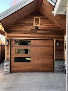 A modern wood-look garage door with horizontal windows installed by Revolution Garage Door, LLC in Corvallis, OR.