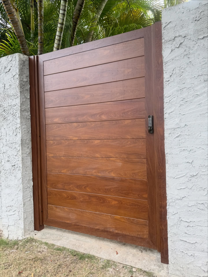 A modern wood-look gate with a keypad entry system installed by A&D Services in Kapolei, HI.