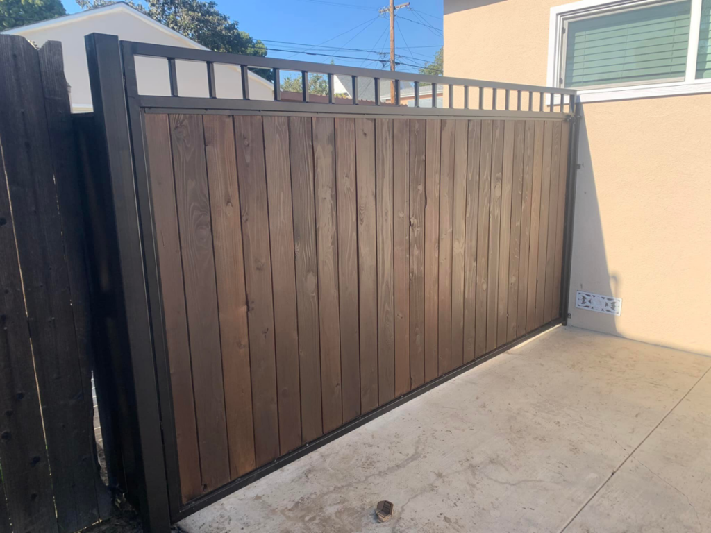 A modern wood and metal fence and gate section, installed by Portugal's IronWorks in Los Angeles, CA.