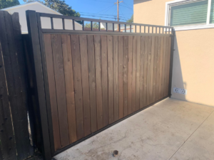 A modern wood and metal fence and gate section, installed by Portugal's IronWorks in Los Angeles, CA.