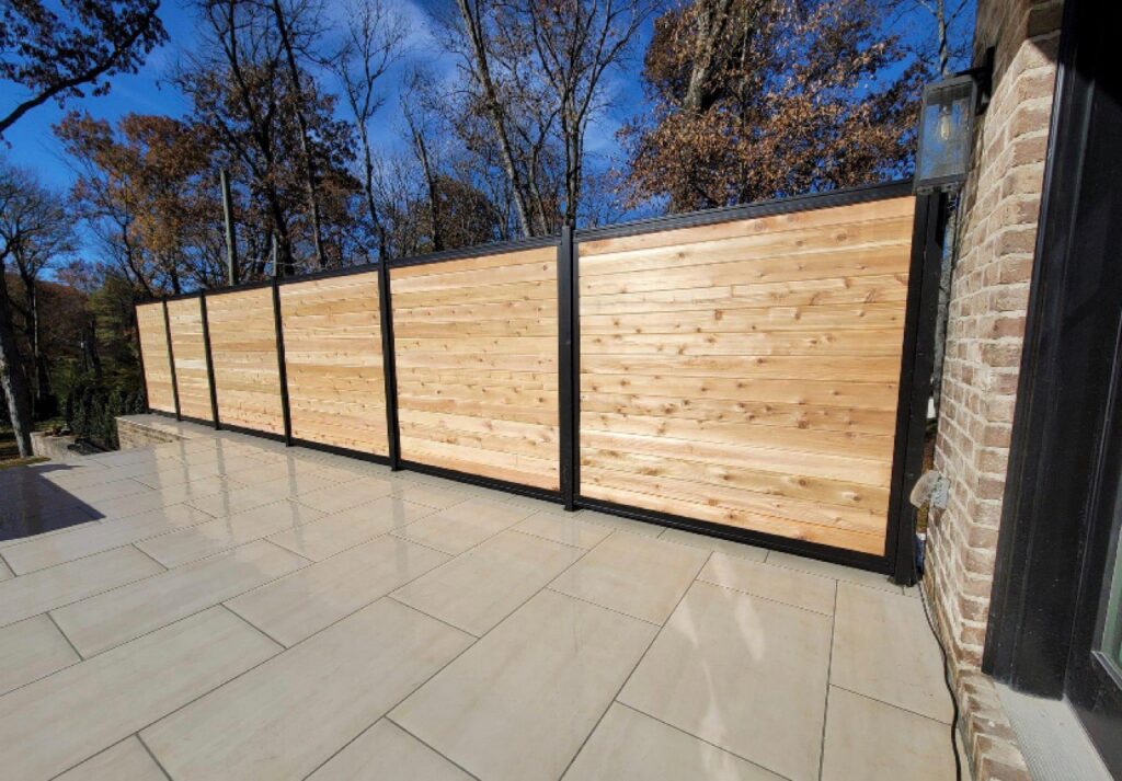 A modern wood and black metal privacy fence installed on a patio by America's Fencing in Nashville, TN.