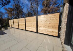 A modern wood and black metal privacy fence installed on a patio by America's Fencing in Nashville, TN.