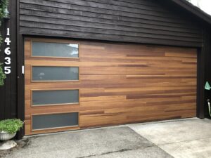 A modern wood panel garage door with frosted windows installed by Revolution Garage Door, LLC in Corvallis, OR.