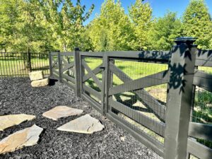 A modern dark grey wood fence with wire mesh inserts and a matching gate, installed by Holmes Fence Company in Chattanooga, TN.