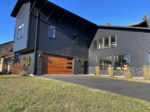 A newly installed modern wooden garage door on a contemporary home by Twin Ports Garage Door in Duluth, MN