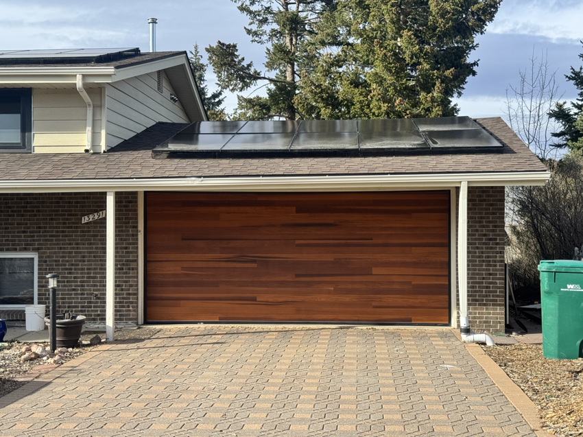 A modern wooden garage door installed on a residential home by Roll-Rite Garage Doors in Denver, CO.